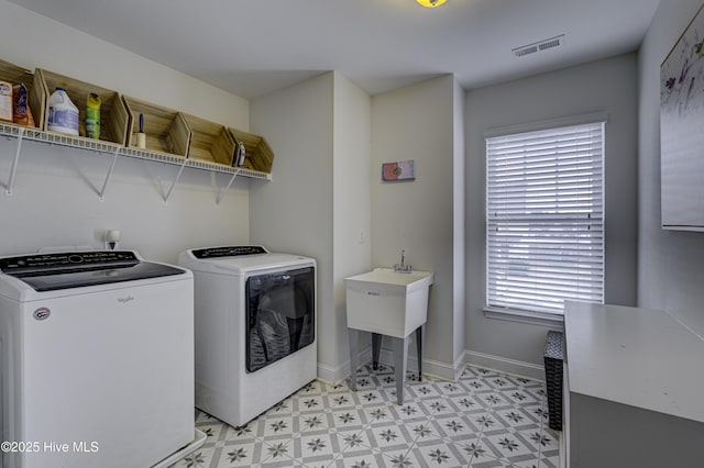 laundry room featuring laundry area, baseboards, visible vents, washer and dryer, and light floors