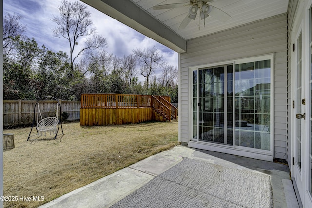 view of patio featuring a wooden deck, stairs, fence, and a ceiling fan