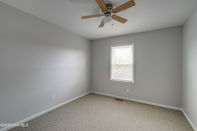 spare room featuring a ceiling fan, carpet, visible vents, and baseboards