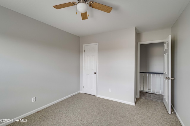 unfurnished bedroom featuring baseboards, a ceiling fan, and light colored carpet