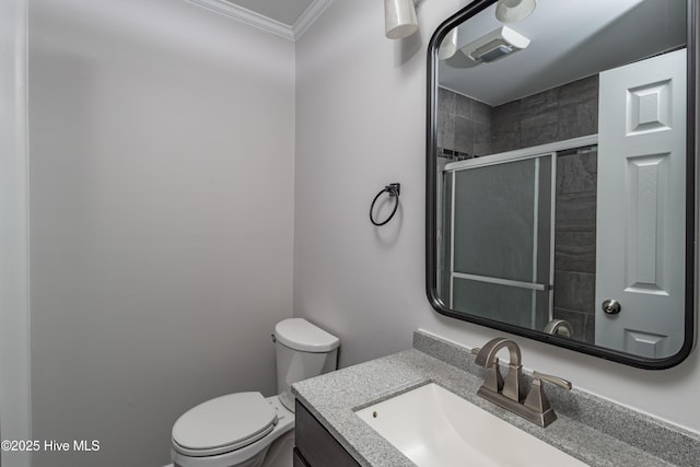 bathroom with ornamental molding, tiled shower, vanity, and toilet