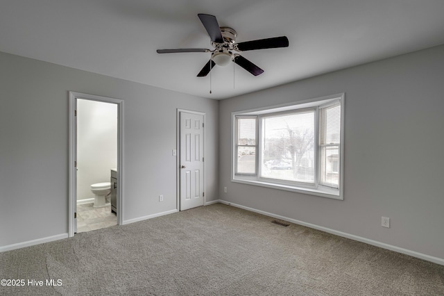 unfurnished bedroom with visible vents, baseboards, a ceiling fan, connected bathroom, and carpet