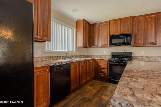 kitchen with black appliances, dark wood-style floors, brown cabinetry, and a sink