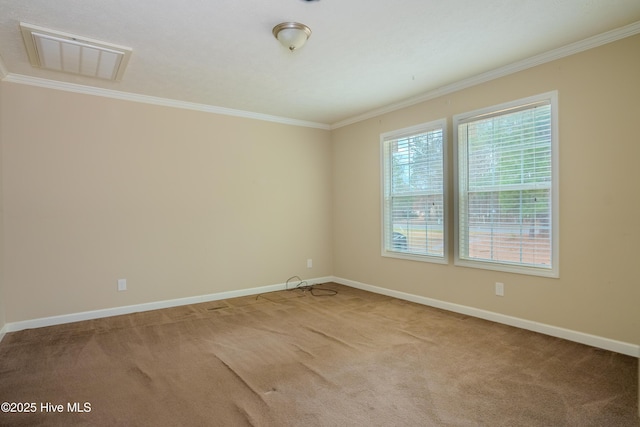 carpeted spare room with ornamental molding, visible vents, and baseboards