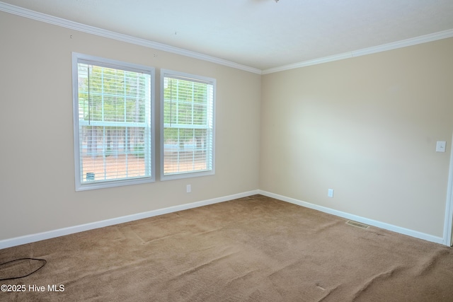 carpeted empty room featuring visible vents, crown molding, and baseboards