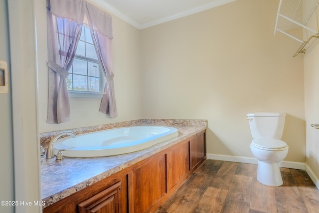 bathroom with baseboards, crown molding, toilet, and wood finished floors