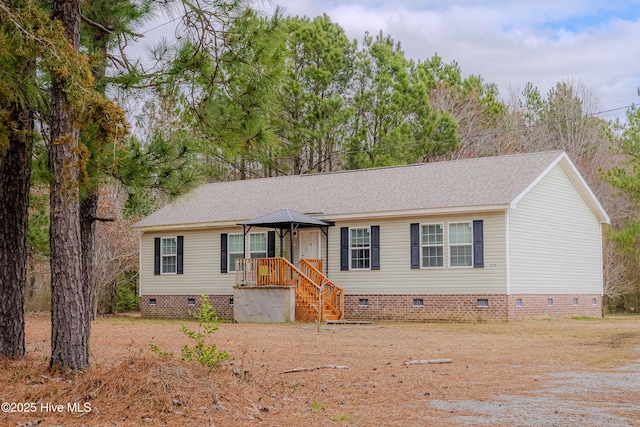 view of front facade with a shingled roof, crawl space, and stairway