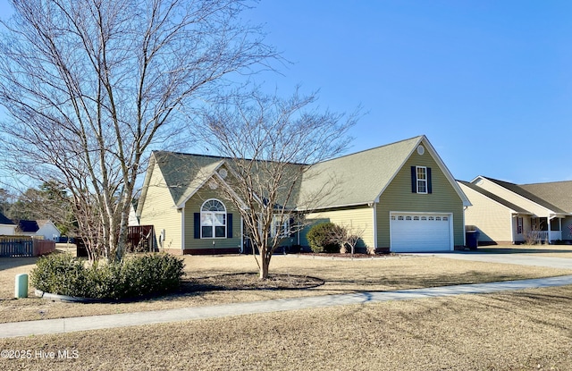 view of front of home with concrete driveway, fence, and an attached garage