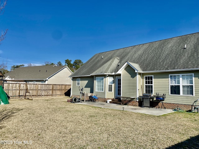 back of house with entry steps, fence, a lawn, and a patio