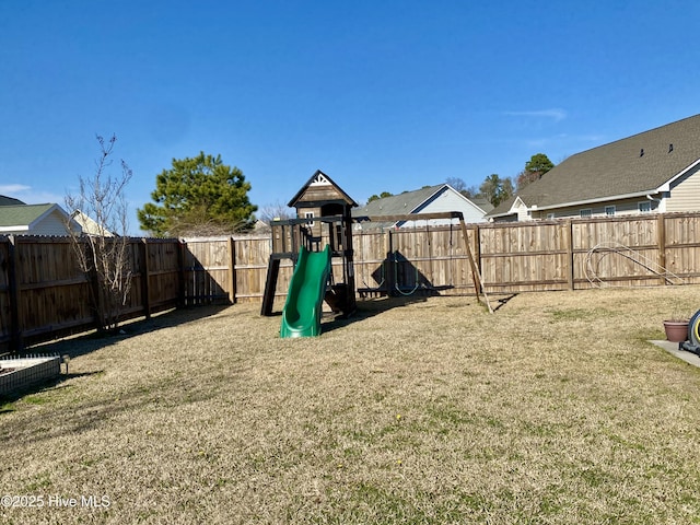 view of playground with a lawn and a fenced backyard