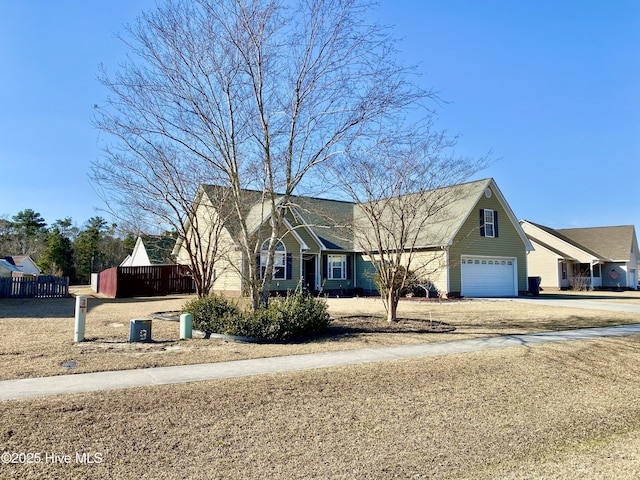 view of front of property featuring concrete driveway, fence, and an attached garage