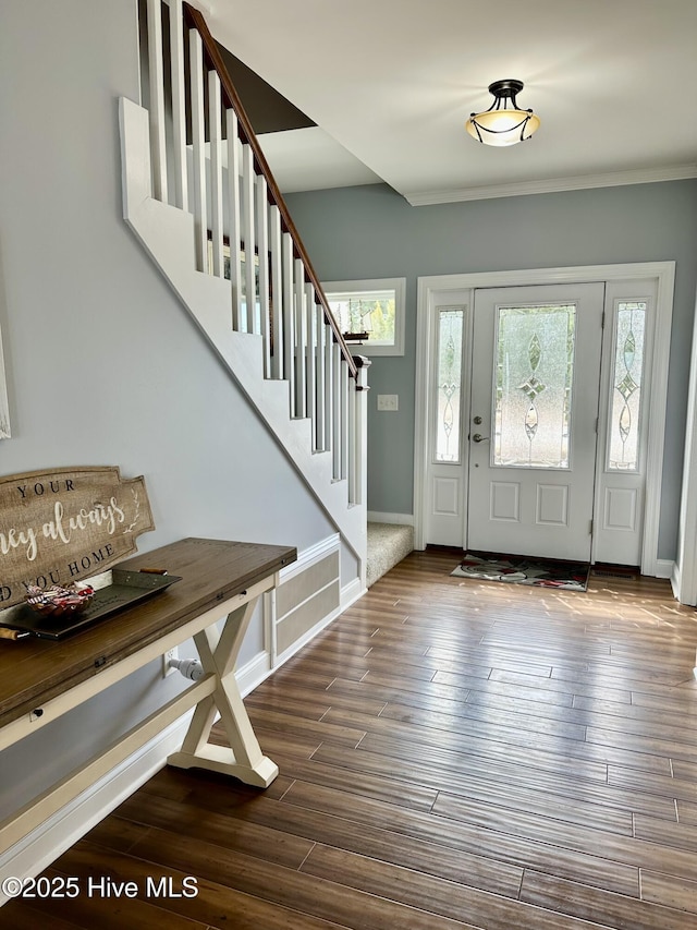 entryway featuring plenty of natural light, stairway, dark wood-type flooring, and baseboards