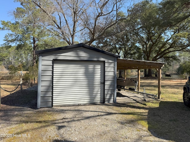 view of outdoor structure with gravel driveway, a carport, and an outdoor structure