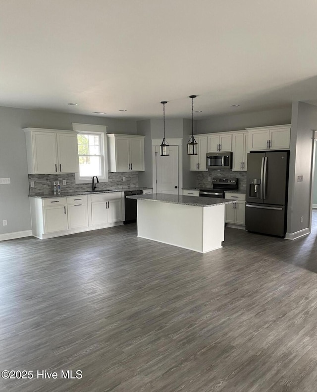 305 Pine Knoll Cir, Pine Knoll Shores, NC 28512 - kitchen featuring appliances with stainless steel finishes, tasteful backsplash, a sink, white cabinets, and baseboards