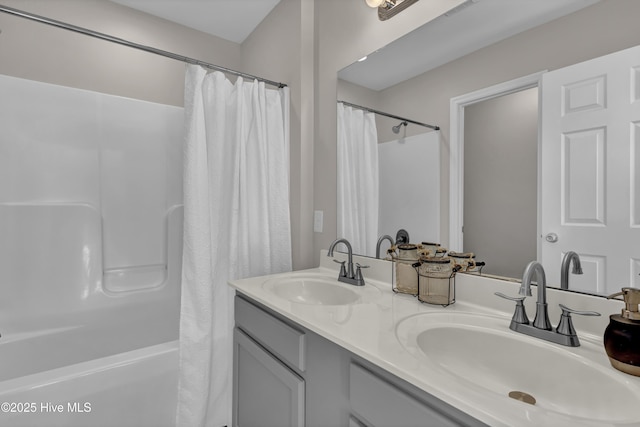 bathroom with double vanity, a sink, and shower / tub combo with curtain