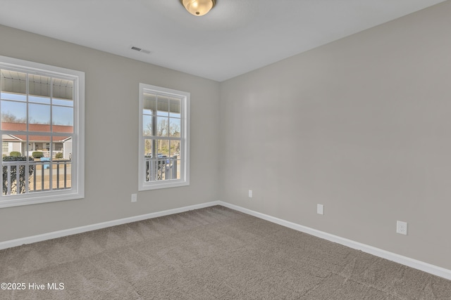 carpeted spare room featuring visible vents and baseboards