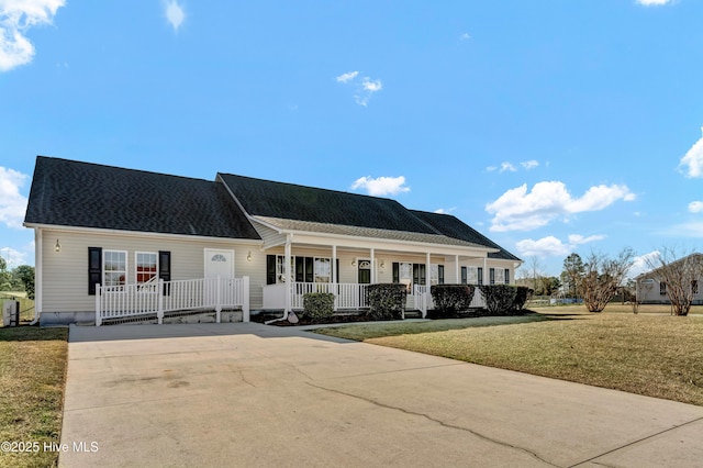 view of front of house with covered porch, roof with shingles, and a front yard