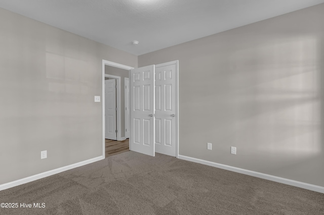 unfurnished bedroom featuring a closet, carpet flooring, and baseboards