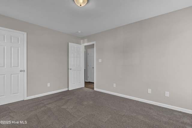 unfurnished bedroom featuring dark colored carpet and baseboards