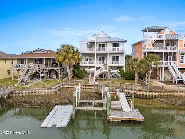 dock area with stairs, a yard, and a water view