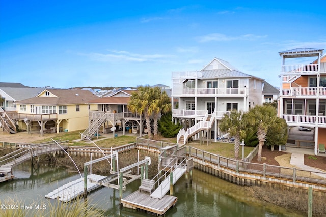 view of dock featuring stairway, a yard, a water view, and boat lift