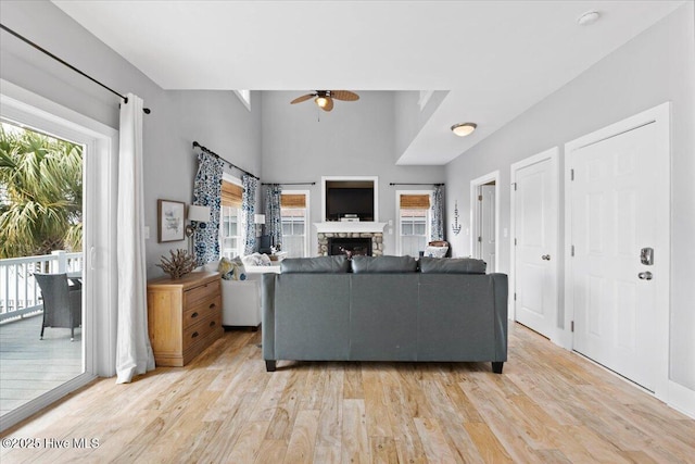 living room with light wood-style floors, a fireplace, and a wealth of natural light