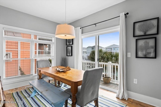 dining area with light wood-style floors and baseboards