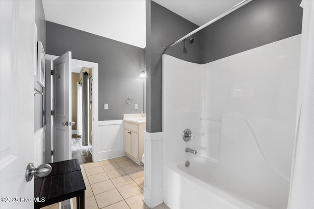 full bathroom featuring tile patterned floors, shower / bathtub combination, vanity, and wainscoting