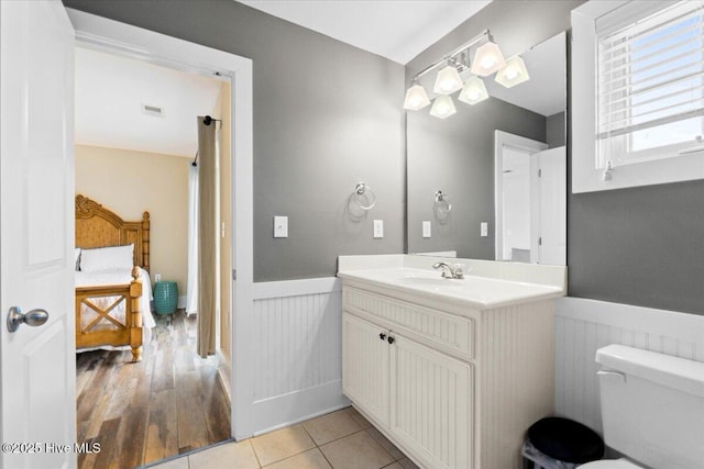 bathroom featuring tile patterned flooring, toilet, a wainscoted wall, visible vents, and vanity