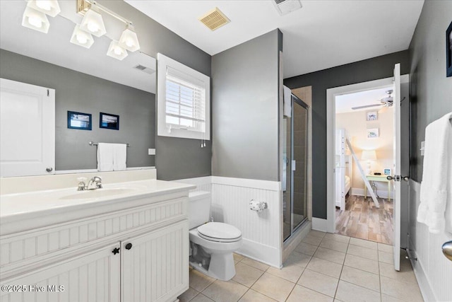 full bathroom featuring visible vents, a wainscoted wall, a stall shower, and tile patterned flooring