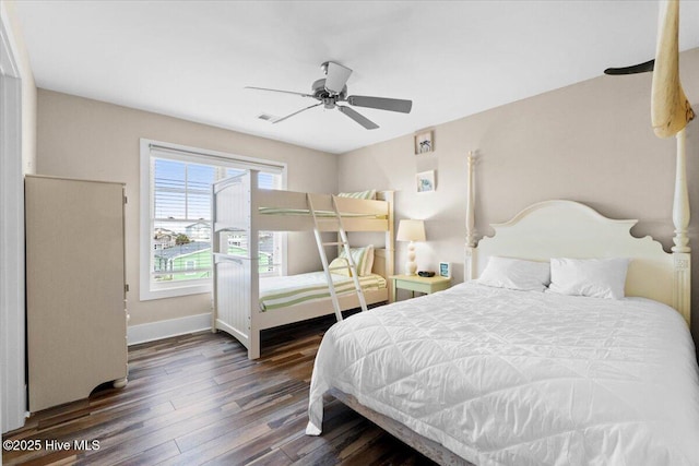 bedroom featuring a ceiling fan, visible vents, baseboards, and wood finished floors