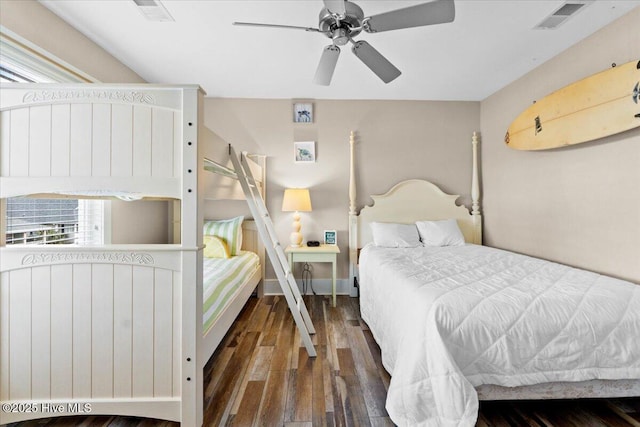 bedroom featuring ceiling fan, visible vents, baseboards, and wood finished floors