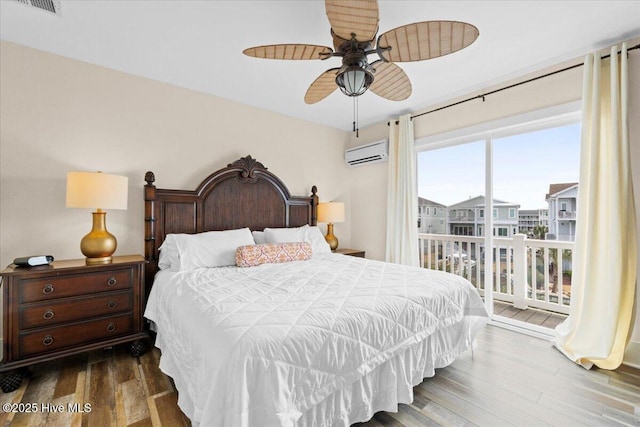 bedroom featuring visible vents, a ceiling fan, dark wood-style flooring, and a wall unit AC
