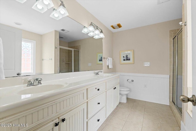 full bath with tile patterned floors, visible vents, a stall shower, a sink, and wainscoting