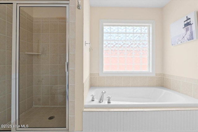 full bathroom with a wealth of natural light, a garden tub, and a stall shower