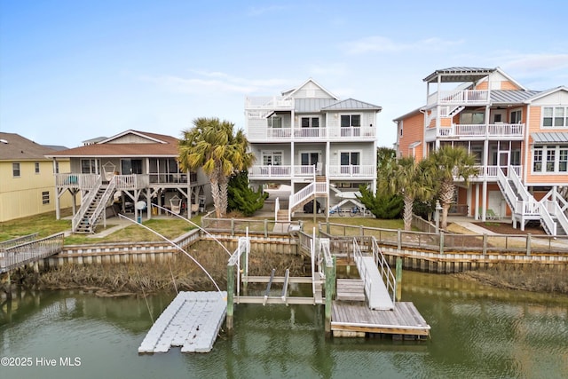 view of dock featuring stairs, a lawn, and a water view