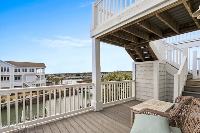 wooden terrace with stairs and a water view