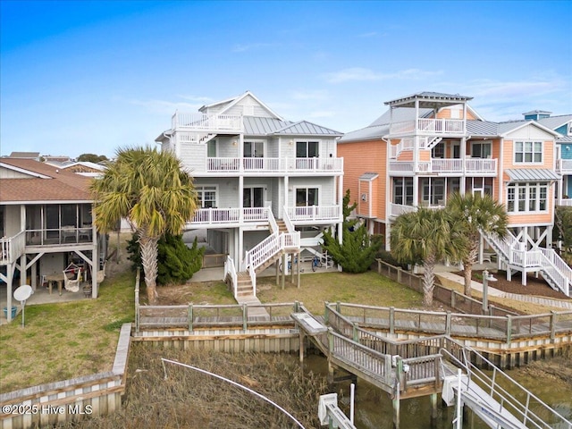 view of dock featuring a water view, stairway, and a lawn