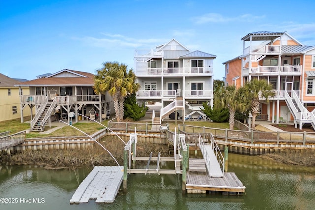 view of dock featuring a lawn, stairs, and a water view