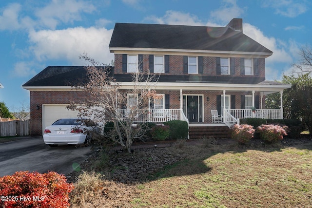 view of front of property featuring an attached garage, driveway, a porch, and brick siding