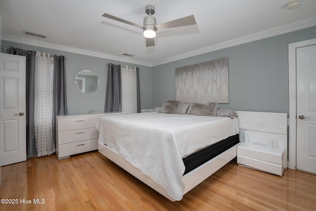 bedroom featuring ceiling fan, ornamental molding, visible vents, and light wood-style floors