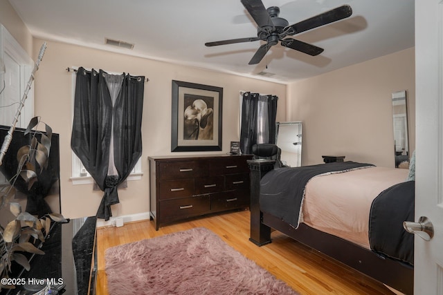 bedroom featuring light wood-type flooring, ceiling fan, and visible vents