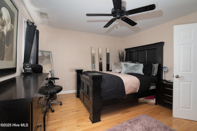 bedroom featuring light wood finished floors, baseboards, visible vents, and a ceiling fan