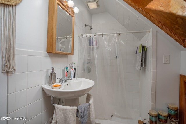 bathroom with a stall shower, visible vents, and tile walls