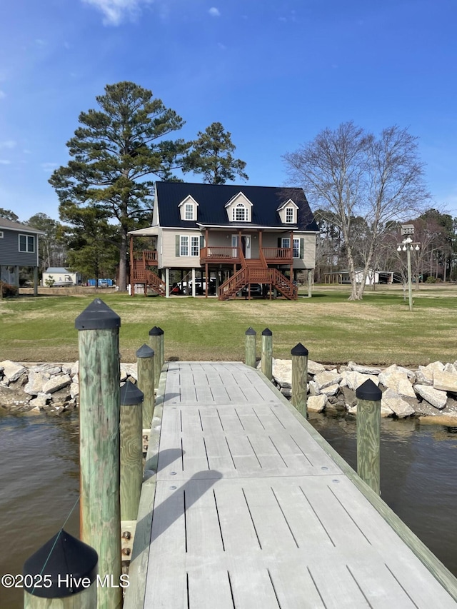 dock area with stairway, a lawn, and a deck