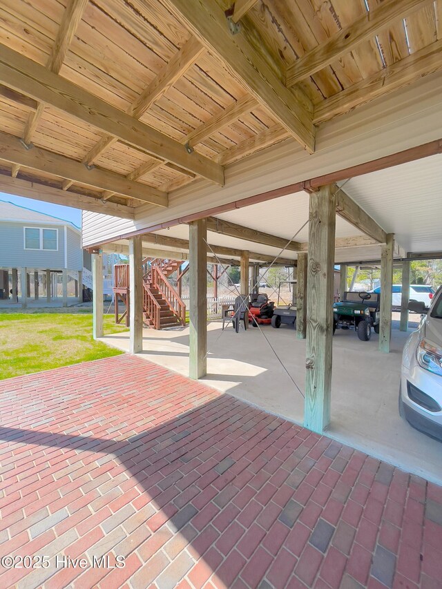 exterior space with stairs, metal roof, a carport, and driveway