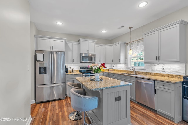 kitchen featuring appliances with stainless steel finishes, dark wood-style flooring, visible vents, and a sink