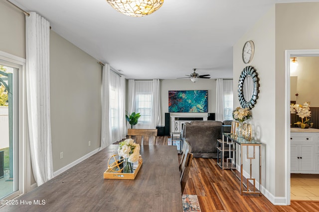 dining room with a ceiling fan, baseboards, and wood finished floors