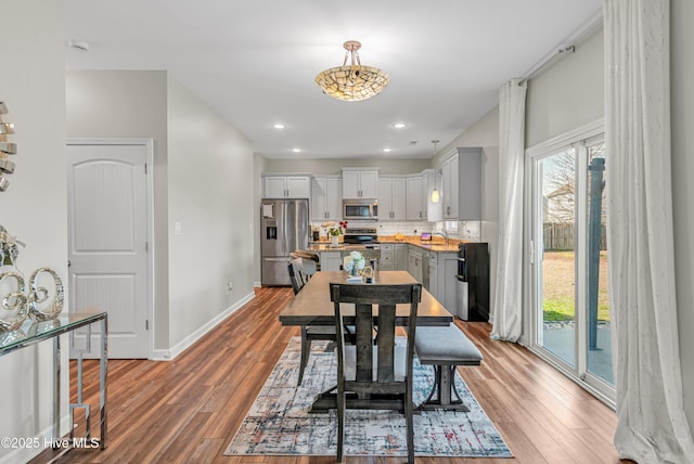 dining room featuring recessed lighting, light wood-type flooring, and baseboards