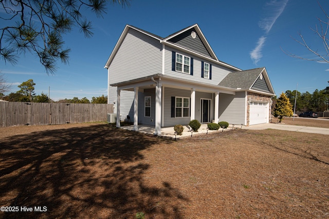 traditional-style home with concrete driveway, fence, and an attached garage